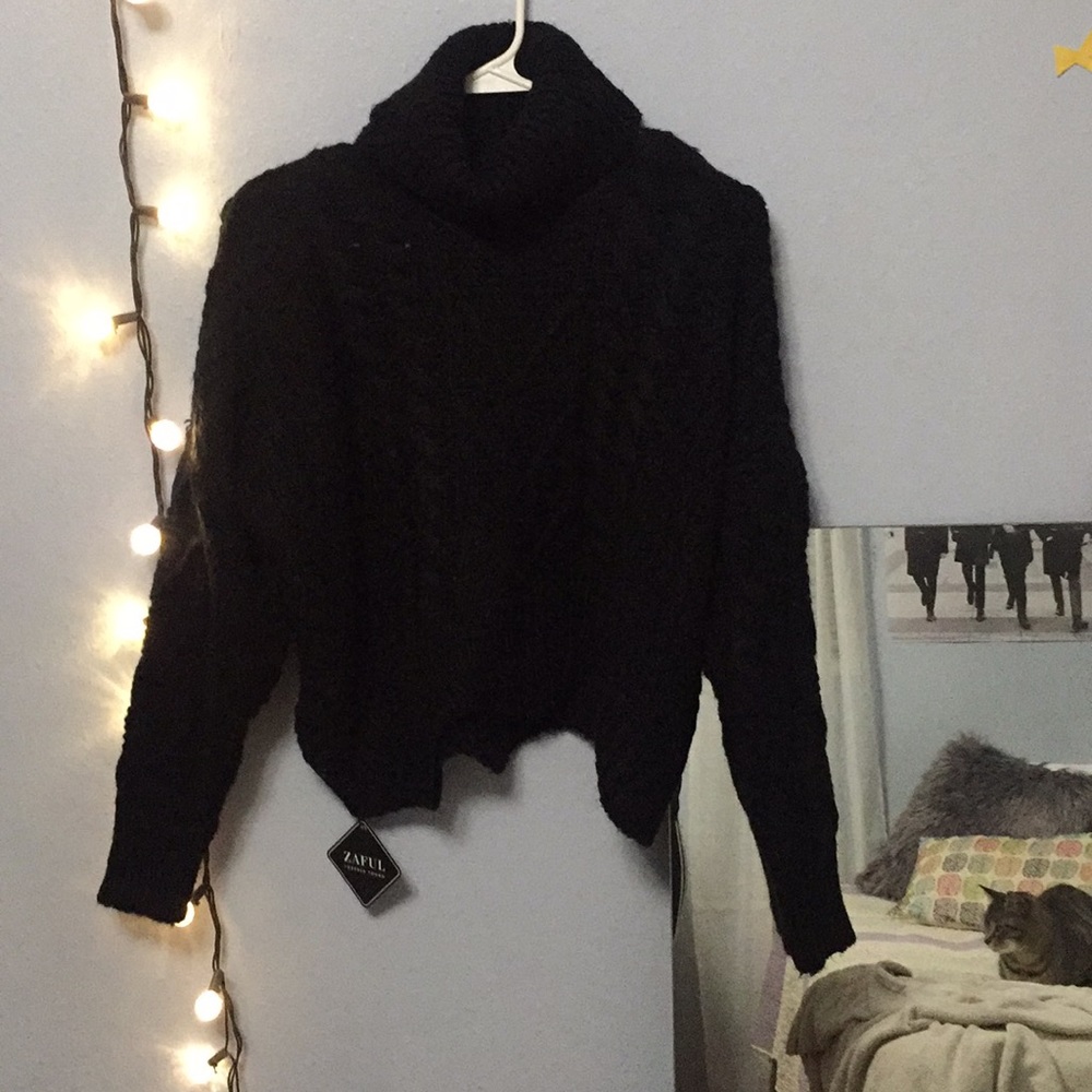 Oversized black knitted turtleneck sweater.